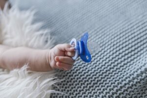 Baby with a nipple. Close up of baby hands with pacifier. Focus